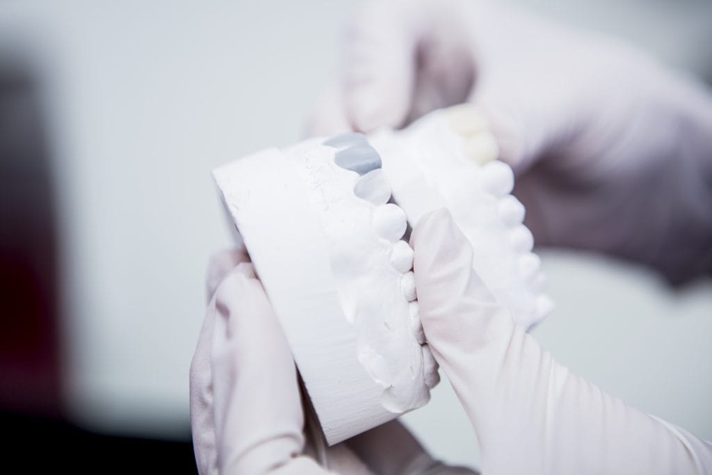 Hands holding dentures