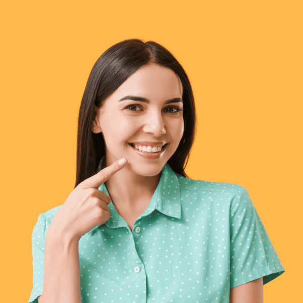 Smiling woman pointing at her healthy teeth